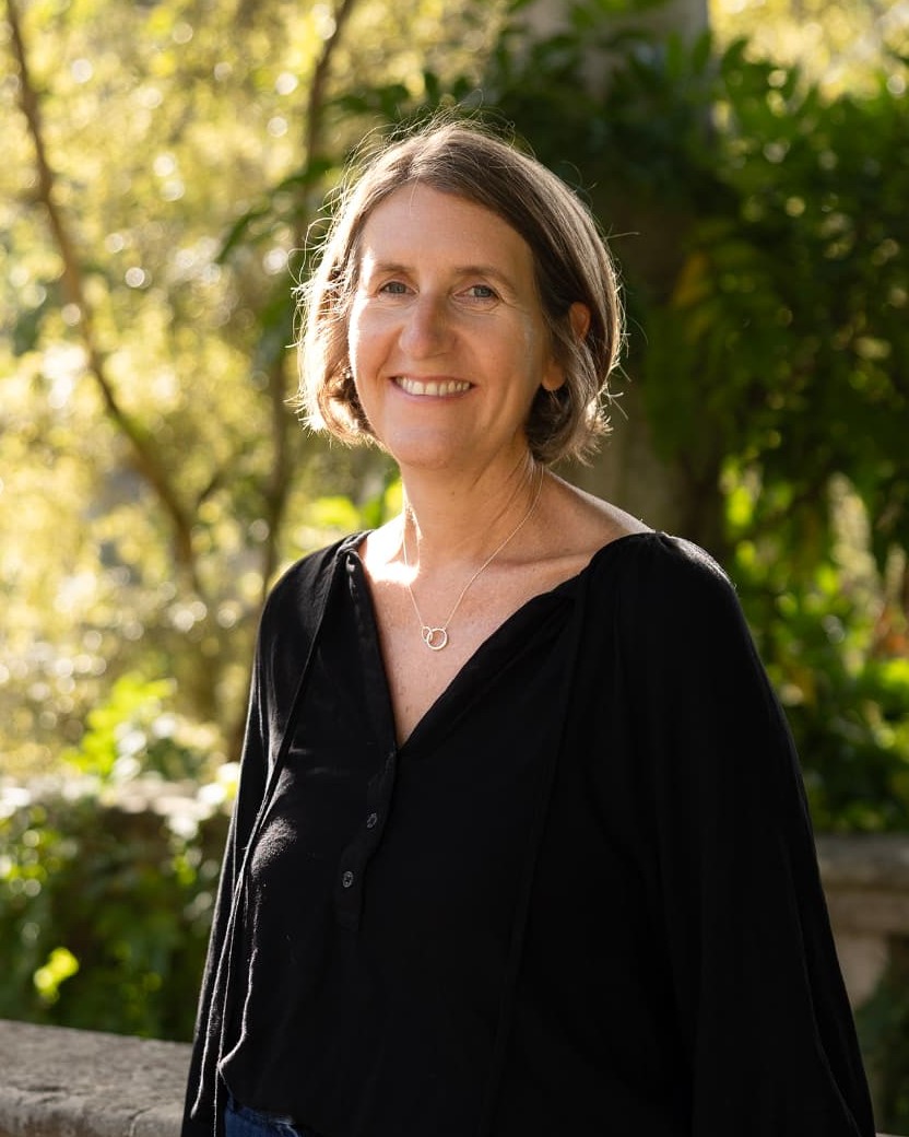 Anna Blair, cancer coach, smiling in a sunlit garden